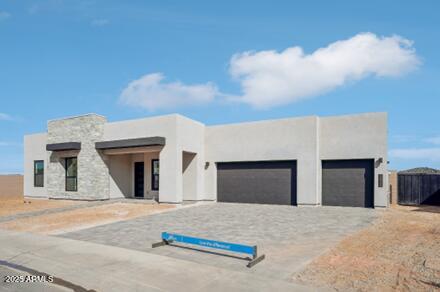 view of front of house featuring a garage, driveway, and stucco siding