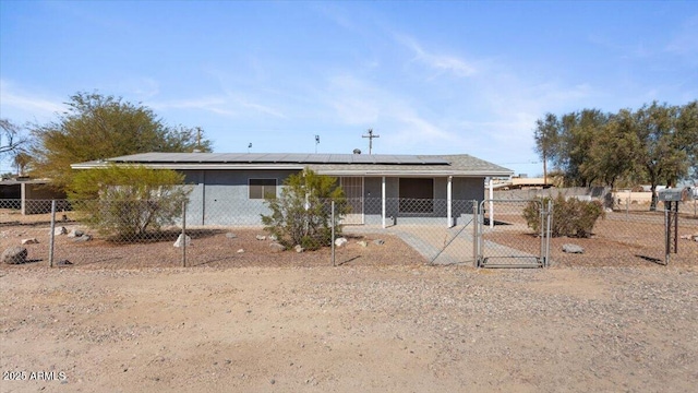 view of front facade with roof mounted solar panels and fence