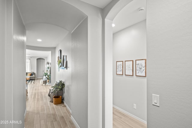 3505 W Verde River Rd, San Tan Valley, AZ 85144 - hallway featuring light wood-style floors, arched walkways, recessed lighting, a textured wall, and baseboards