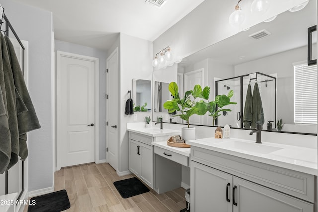 3505 W Verde River Rd, San Tan Valley, AZ 85144 - bathroom with double vanity, a stall shower, visible vents, a sink, and wood finished floors