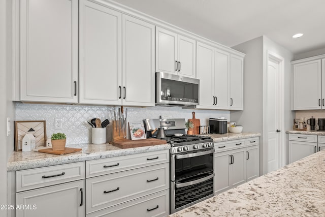 3505 W Verde River Rd, San Tan Valley, AZ 85144 - kitchen featuring appliances with stainless steel finishes, white cabinetry, recessed lighting, light stone countertops, and decorative backsplash
