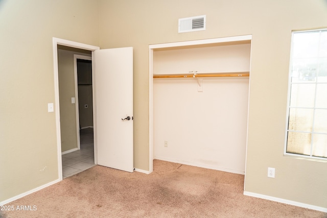 unfurnished bedroom featuring a closet and light carpet