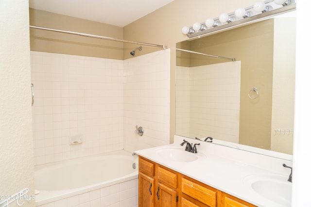 bathroom with tiled shower / bath combo and vanity