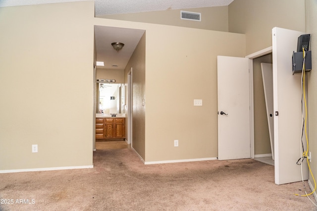 spare room featuring vaulted ceiling and light colored carpet