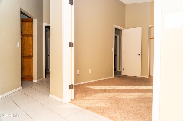 hall with a high ceiling and light colored carpet