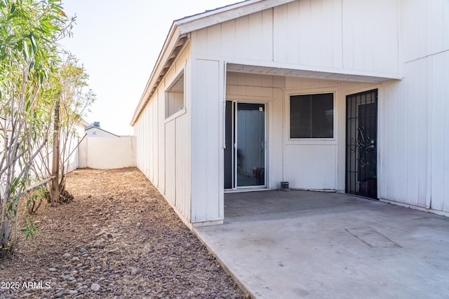 view of exterior entry with a patio area