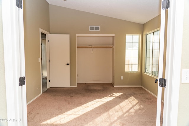 unfurnished bedroom featuring vaulted ceiling and light colored carpet