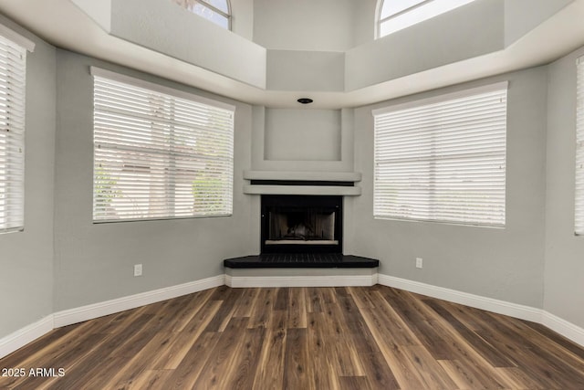3832 N Gallatin, Mesa, AZ 85215 - unfurnished living room with baseboards, a high ceiling, wood finished floors, and a fireplace with raised hearth