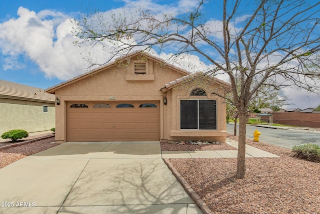 view of front of home with stucco siding, concrete driveway, and an attached garage