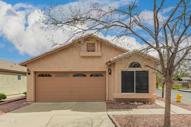 view of front of property featuring a garage, driveway, and stucco siding