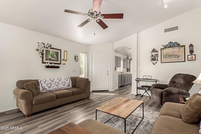 living room with visible vents, lofted ceiling, wood finished floors, arched walkways, and a ceiling fan