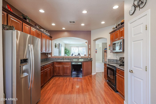 kitchen with ceiling fan, sink, light hardwood / wood-style floors, a textured ceiling, and black appliances