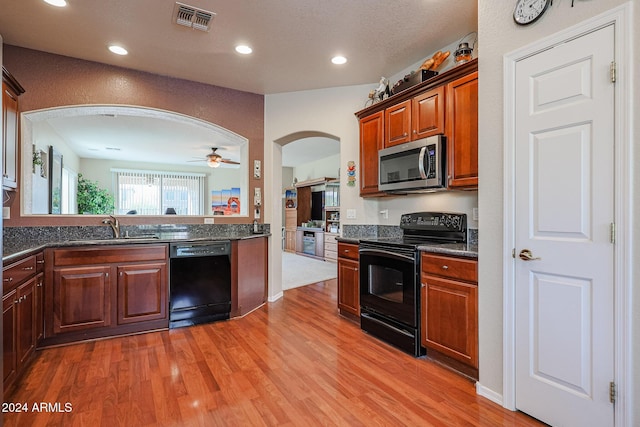 kitchen with black appliances, ceiling fan, sink, and light hardwood / wood-style flooring