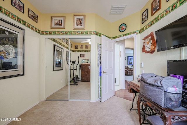 interior space with ceiling fan and light colored carpet