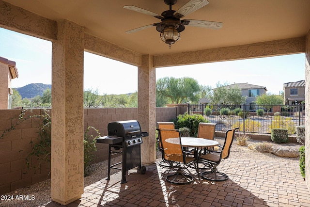 view of patio / terrace featuring a grill, ceiling fan, and a mountain view