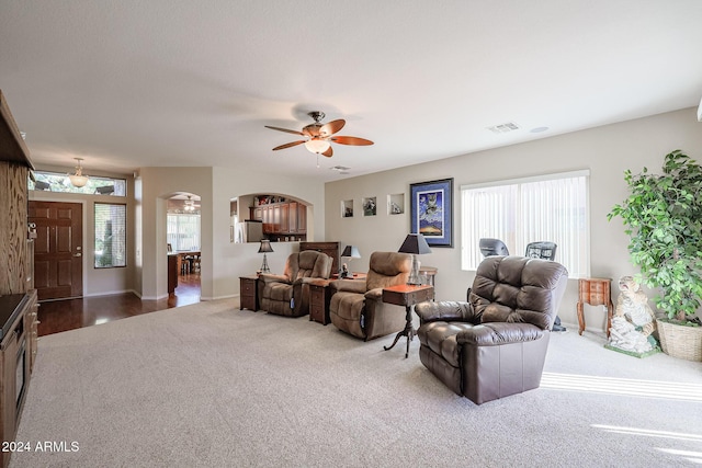 living room featuring ceiling fan, a healthy amount of sunlight, and light colored carpet