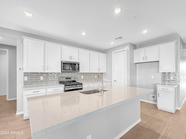 kitchen featuring white cabinets, a center island with sink, sink, and appliances with stainless steel finishes