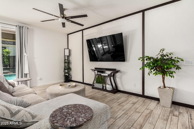 living room featuring ceiling fan, wood finished floors, and baseboards