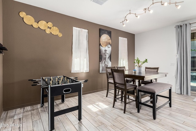 dining space featuring visible vents, light wood-style flooring, and baseboards