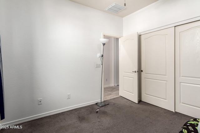 unfurnished bedroom featuring baseboards, a closet, visible vents, and carpet flooring