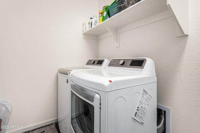 washroom featuring laundry area, washing machine and dryer, and baseboards