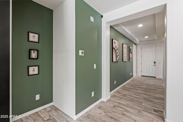 corridor with baseboards, recessed lighting, and light wood-style floors