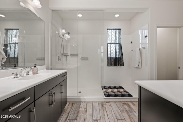 bathroom with a stall shower, wood finished floors, and vanity
