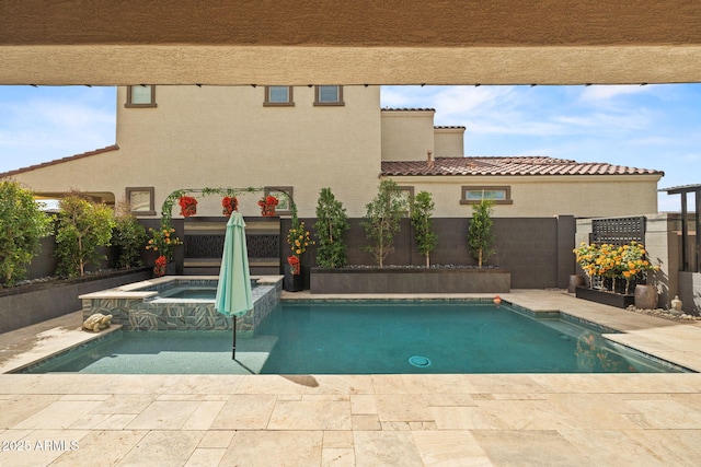 view of swimming pool with a patio area, a fenced backyard, and a pool with connected hot tub