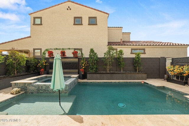 view of swimming pool with a pool with connected hot tub and a fenced backyard