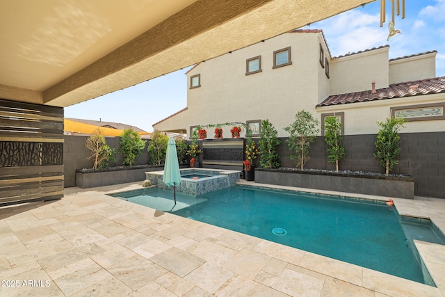 view of swimming pool featuring a pool with connected hot tub, a patio area, and a fenced backyard