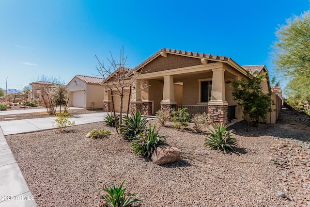 view of front of property with covered porch, a garage, stone siding, concrete driveway, and stucco siding