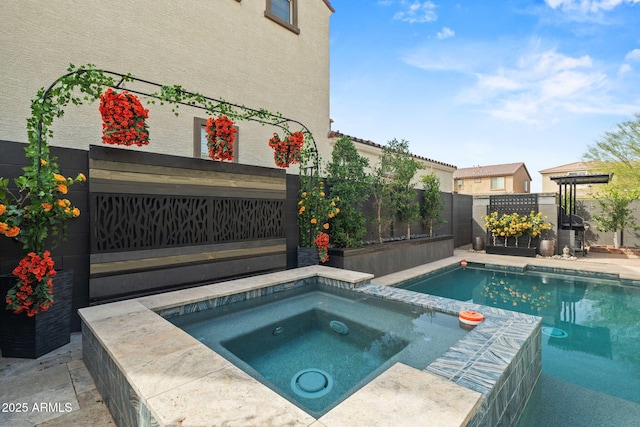 view of swimming pool with a pool with connected hot tub and a fenced backyard