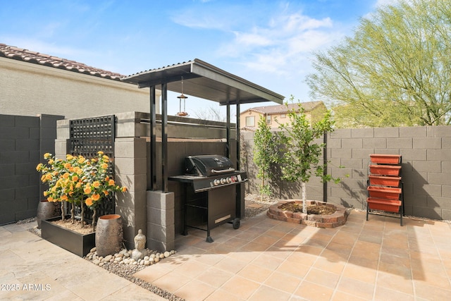 view of patio with area for grilling and fence