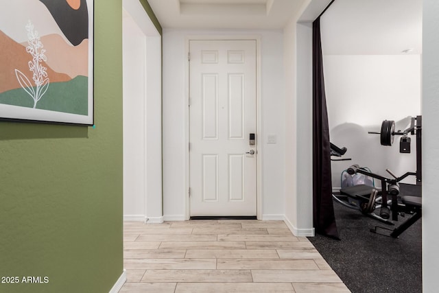 foyer featuring wood tiled floor and baseboards