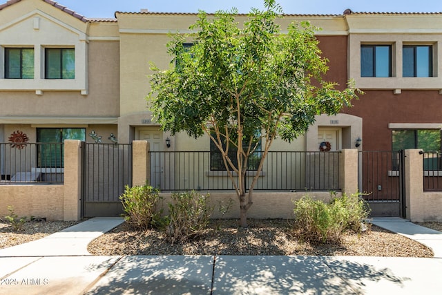 125 N Sunvalley Blvd Unit 119, Mesa, AZ 85207 - townhome / multi-family property featuring a gate, stucco siding, and a fenced front yard