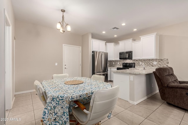 125 N Sunvalley Blvd Unit 119, Mesa, AZ 85207 - kitchen with black appliances, backsplash, a peninsula, white cabinets, and light tile patterned floors