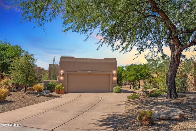 pueblo-style house featuring a garage