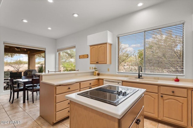 kitchen featuring light brown cabinets, a center island, black cooktop, and light tile patterned flooring