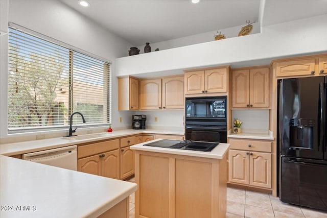 kitchen with light brown cabinetry, black appliances, and a center island