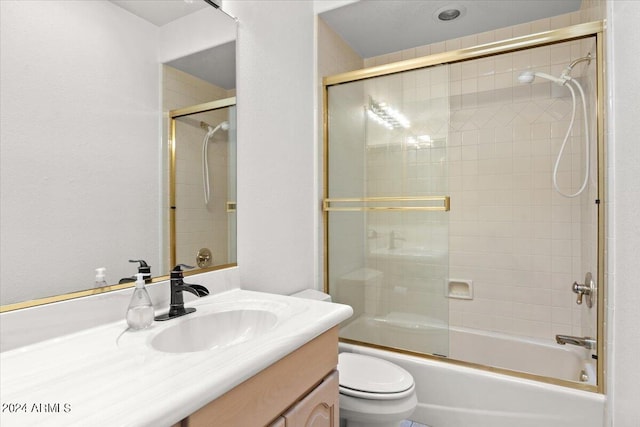 full bathroom with enclosed tub / shower combo, vanity, and toilet