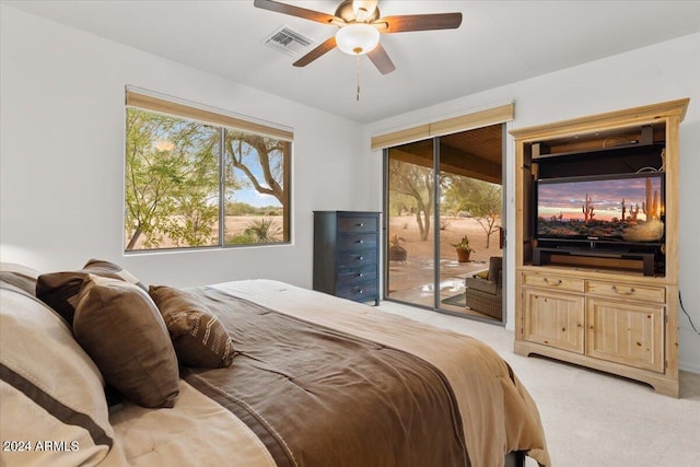 carpeted bedroom with multiple windows, access to outside, and ceiling fan