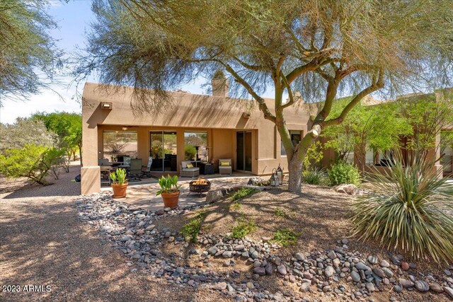 rear view of property featuring an outdoor living space and a patio area