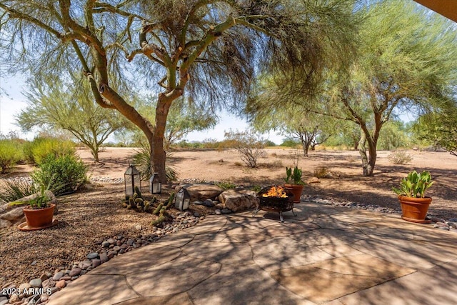 view of patio with a fire pit and a rural view