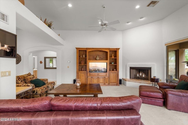 carpeted living room with a high ceiling and ceiling fan