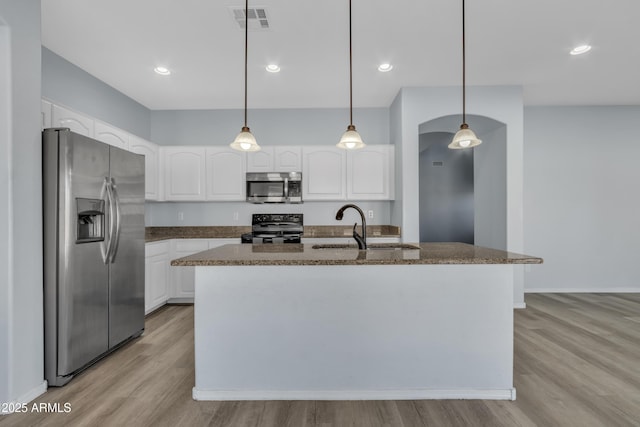 kitchen featuring stainless steel appliances, sink, pendant lighting, white cabinetry, and an island with sink