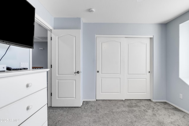 unfurnished bedroom with a closet and light colored carpet