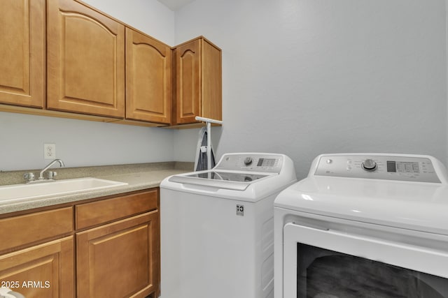 laundry room featuring cabinets, sink, and washing machine and clothes dryer