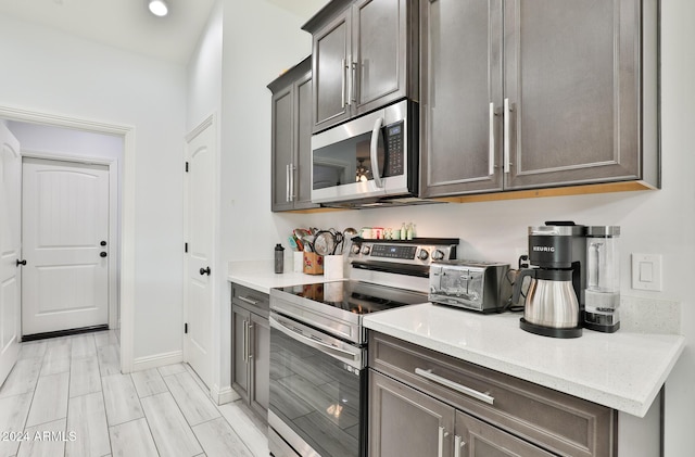 kitchen featuring appliances with stainless steel finishes and light stone counters