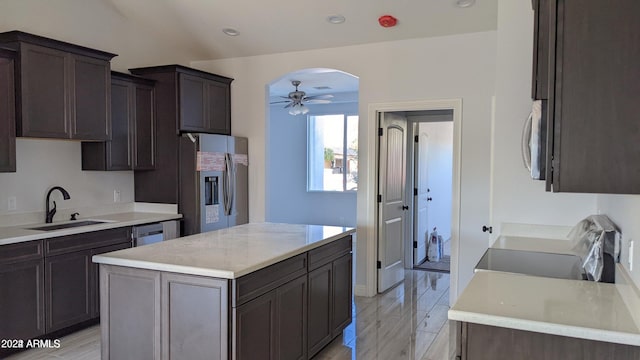 kitchen featuring stainless steel appliances, a kitchen island, ceiling fan, and light hardwood / wood-style floors