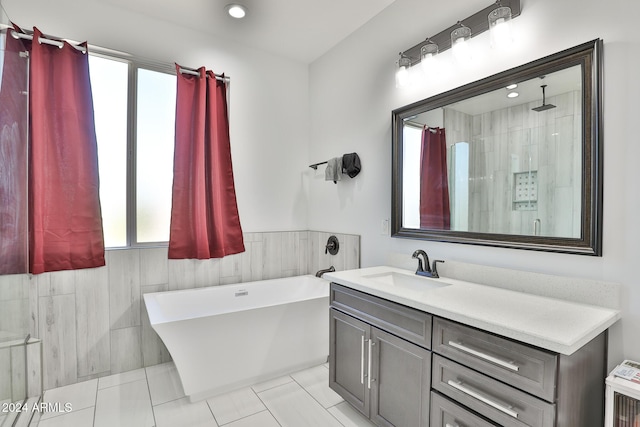 bathroom featuring tile patterned flooring, vanity, and shower with separate bathtub